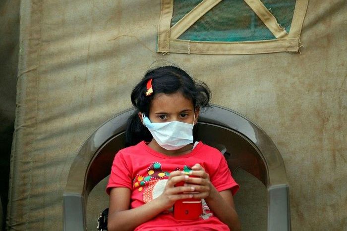 A Yemeni child suspected of being infected with cholera sits outside a makeshift hospital in Sanaa