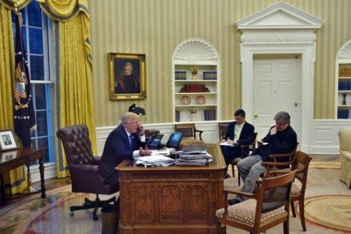 US President Donald Trump speaks on the phone with Australians Prime Minister Malcolm Turnbull, alongside Chief Strategist Steve Bannon (R) and National Security Advisor Michael Flynn, in the Oval Office on January 28, 2017