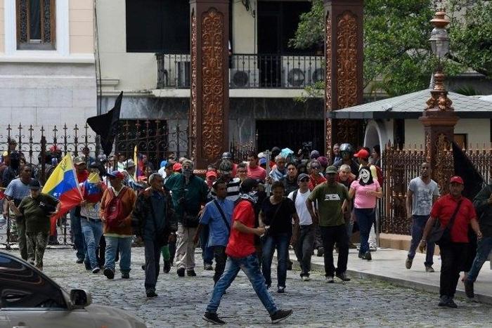 Stick-wielding supporters of Venezuelan President Nicolas Maduro broke through the front gate of the National Assembly building and set off fireworks in the interior gardens