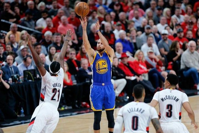 Stephen Curry of the Golden State Warriors shoots the ball over Noah Vonleh of the Portland Trail Blazers in Game Three of the Western Conference quarter-finals of the 2017 NBA Playoffs, in Portland, Oregon, on April 22