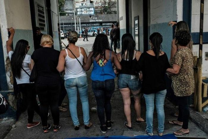 Wives and widows of military policemen block the entrance to the military police station in Rio de Janeiro on February 10, as they demand back pay for their relatives