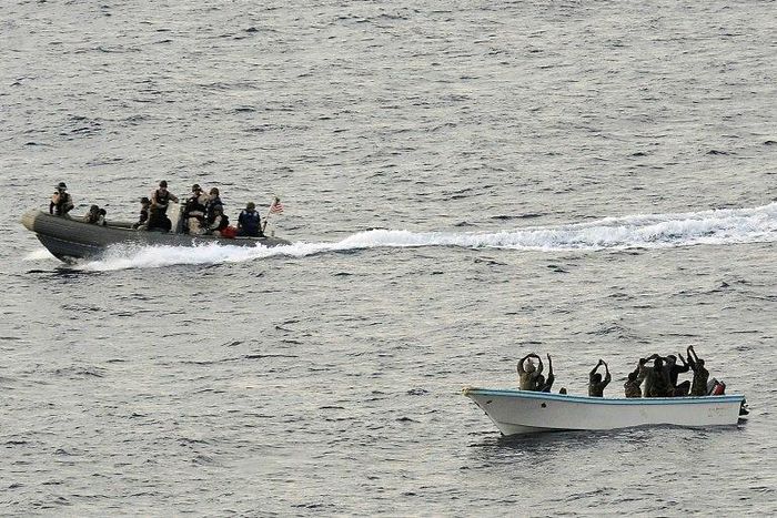 Search and seizure team members (L) from the USS Vella Gulf close in to apprehend suspected pirates (R) in the Gulf of Aden in 2009
