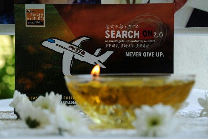 A candle burns a prayer message for passengers of missing Malaysia Airlines flight MH370 in Petaling Jaya on March 8, 2016
