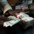 A trader changes dollars with naira at a currency exchange store in Lagos, Nigeria, February 12, 2015. REUTERS/Joe Penney