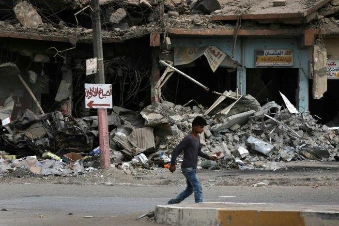 A boy walks along a damaged street in west Mosul on July 13, 2017, a few days after the government's announcement of the "liberation" of the city from the Islamic State group