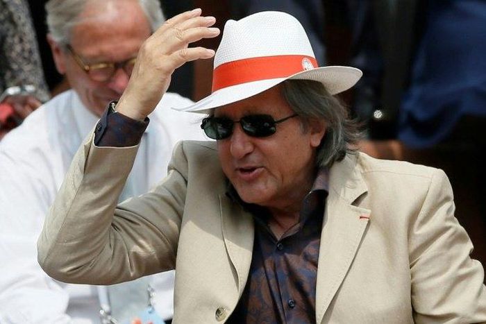 Romanian former tennis player Ilie Nastase salutes the crowd at the French Open in 2013
