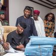 Acting President, Prof. Osinbajo signing the budget with other officials of government .