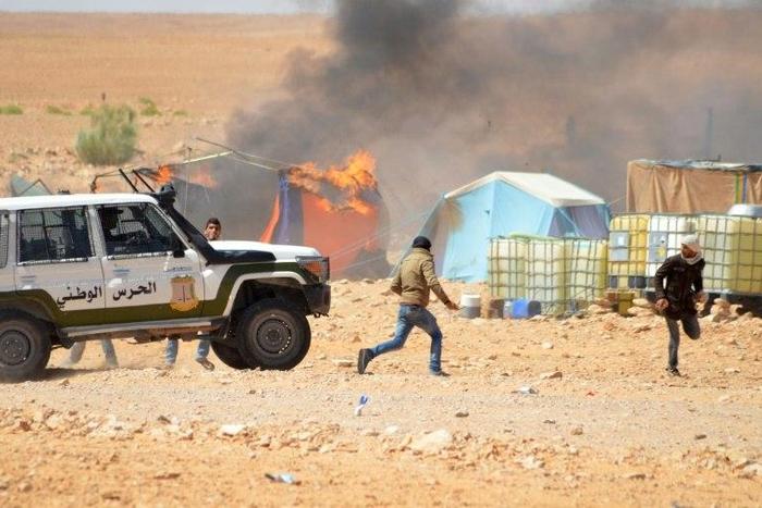 Tunisian protesters comfront security forces outside the El Kamour oil and gas pumping station, in the southern state of Tataouine, on May 22, 2017