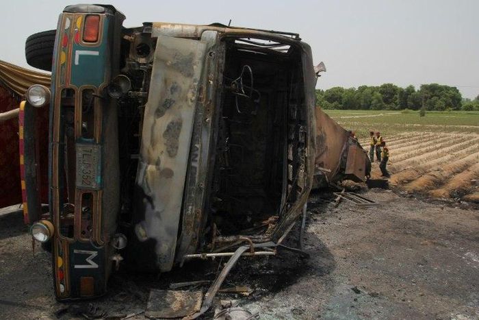 Pakistani rescue workers gather beside an oil tanker which caught fire following an accident on a highway near the town of Ahmedpur East