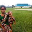 A woman holds a child in her arms as she arrives at Yathae Taung township in Rakhine state after fleeing violence in their home village