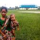 A woman holds a child in her arms as she arrives at Yathae Taung township in Rakhine state after fleeing violence in their home village