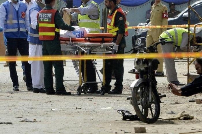 Pakistani security officials collect evidence from the scene of an attack on a census team in Lahore