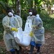Red Cross volunteers, wearing protective clothing, carry the body of a person who died from Ebola during a burial in Monrovia, Liberia, on January 5, 2015