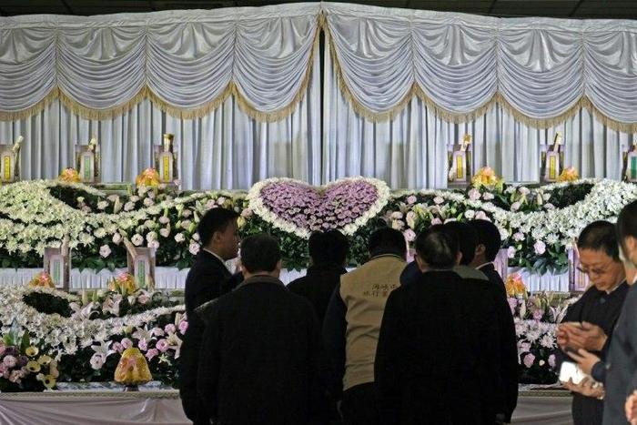Relatives (C) mourn the victims of a bus crash in Taiwan that killed 33 local tourists