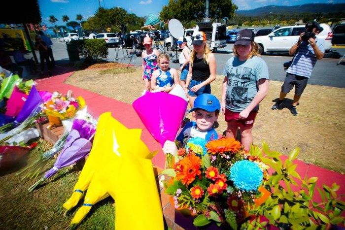 Visitors lay flowers at a makeshift floral tribute at the Dreamworld theme park in Gold Coast on October 26, 2016, a day after four people were killed when a raft flipped at one of the park's attractions