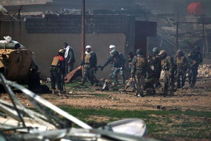 Iraqi security forces evacuate comrades wounded in an explosives-laden vehicle attack claimed by Islamic State group south of Mosul