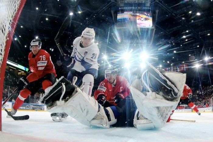 France's forward Antoine Roussel (C) vies with Switzerland's defender Raphael Diaz (C) nex to France's goalkeeeper Cristobal Huet (R) during the IIHF Men's World Championship group B ice hockey match between Switzerland and France on May 9, 2017