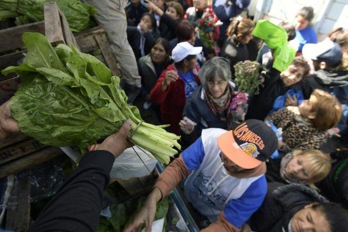 Farmers give away vegetables during a protest at Plaza de Mayo square near the Casa Rosada presidential palace in Buenos Aires, on April 26, 2017
