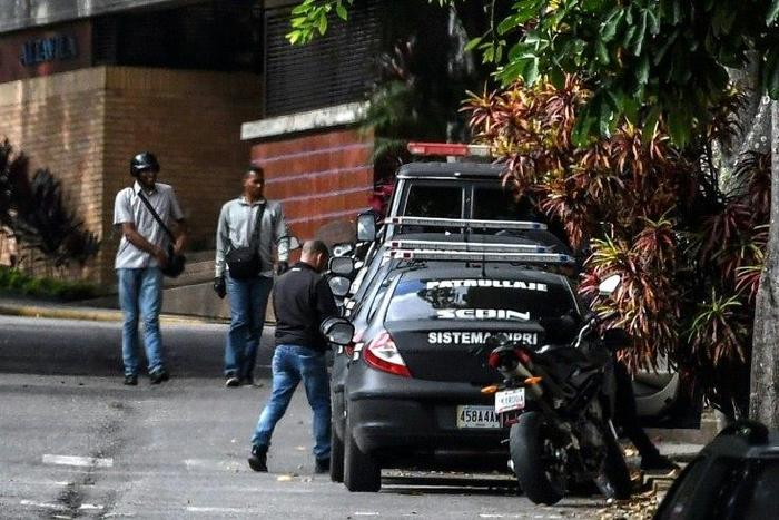 Venezuelan intelligence service members stand guard outside the home of ousted attorney general Luisa Ortega, who says it was raided and searched