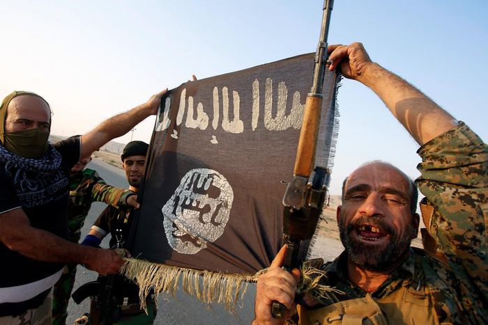 Iraqi Shiite militia fighters hold the Islamic State flag as they celebrate after breaking the siege of Amerli by Islamic State militants.