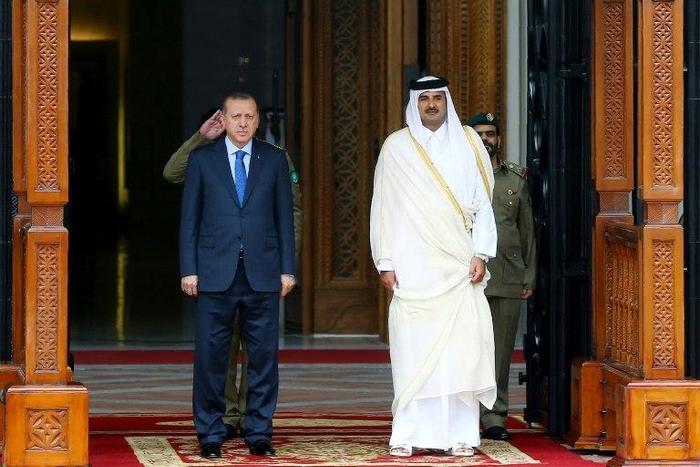 This handout photo taken and released by Turkey's Presidential Press Service on February 15, 2017 shows the Emir of Qatar Tamim bin Hamad Al Thani (R) and Turkish President Recep Tayyip Erdogan (L) attending a welcome ceremony in Doha