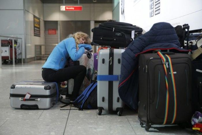 A traveller sleeps next to luggage at London's Heathrow Airport after British Airways cancelled all flights from the major travel hub on May 27, 2017