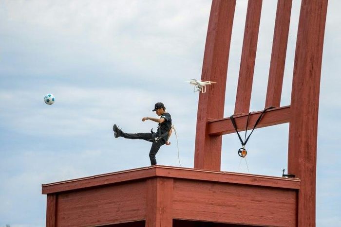 Brazilian superstar and world's most expensive footballer Neymar shoots a ball from the monumental wood sculpture "Broken Chair" during an event by the (NGO) Handicap International on August 15, 2017 at the Place des Nations in Geneva