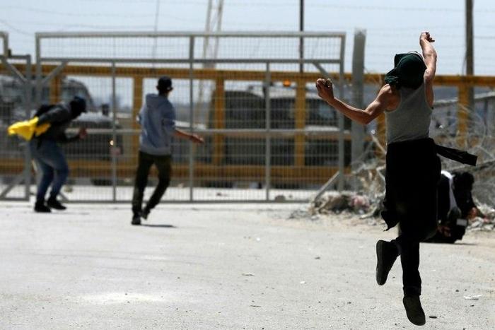 Palestinian protesters hurl stones towards Israeli security forces during clashes following a demonstration in solidarity with hunger-striking Palestinian prisoners, in front of Ofer prison in the West Bank, on April 20, 2017