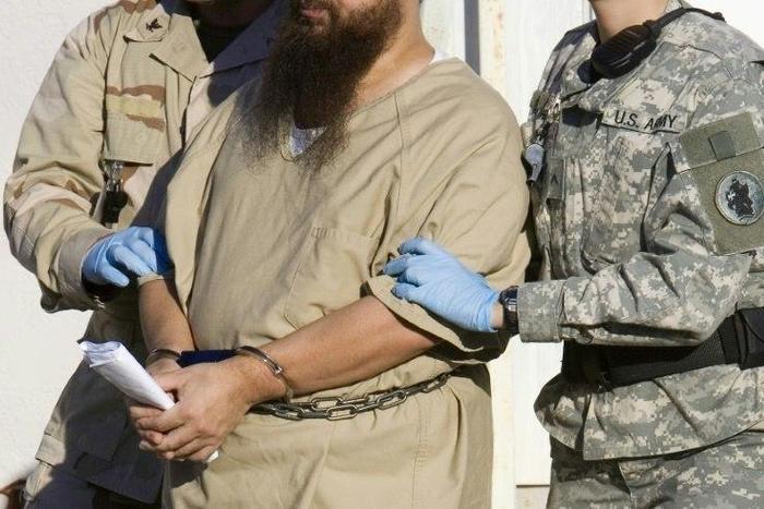 A detainee is escorted by military guards at the US prison at Guantanamo Bay, Cuba, in a 2006 photo