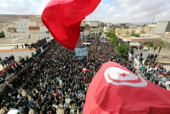 Tunisians wave the national flag during a general strike in the southern city of Tatouine on April 11, 2017