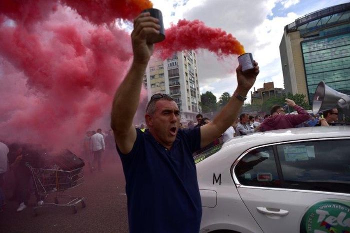A taxi driver brandishes smoke canisters as he protests in Madrid