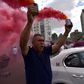 A taxi driver brandishes smoke canisters as he protests in Madrid