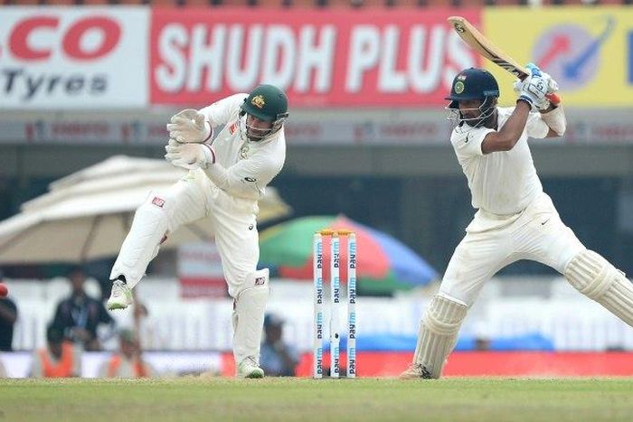 Indian batsman Cheteshwar Pujara plays a shot as Australian wicketkeeper Matthew Wade looks on on the fourth day of their third Test match, at The Jharkhand State Cricket Association (JSCA) Stadium Complex in Ranchi, on March 19, 2017