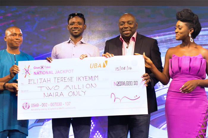 Elijah Iykemum receiving his cheque from Give 'N' Take