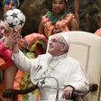 A Cuban circus artist helps Pope Francis juggle a football during his weekly audience on Wednesday