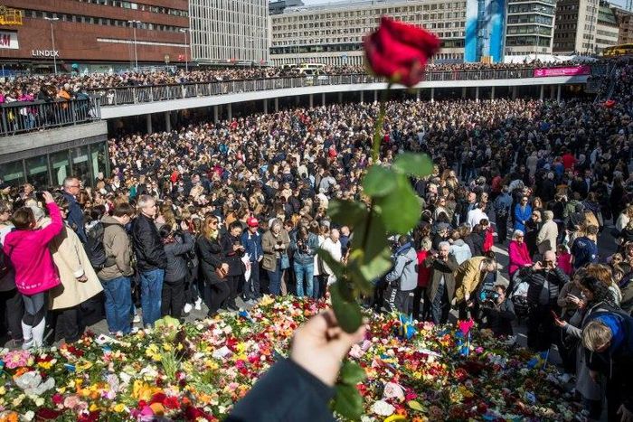 People attend a memorial ceremony on April 9, 2017 at Sergels Torg plaza in Stockholm, close to the point where a truck drove into a department store two days before