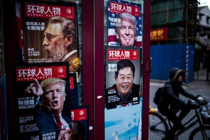 Advertisements for a magazine showing various cover stories, including ones featuring US President-elect Donald Trump, at a newsstand in Shanghai