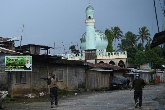 Government troops patrol a deserted street near the position of Islamic militants in Marawi, on the southern island of Mindanao on May 27, 2017