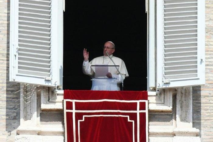 Pope Francis waves to pilgrims gathered in St. Peter's square during his Sunday Angelus prayer on August 20, 2017 at the Vatican