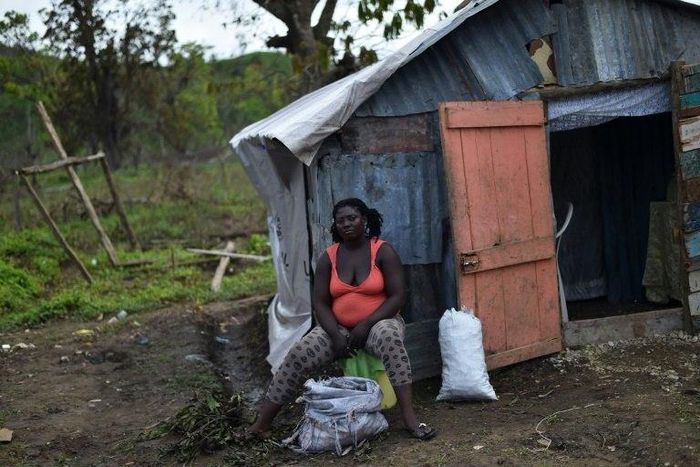 A woman displaced by Hurricane Matthew sits outside her house in the neighborhood of Gebeaux in the commune of Jeremie, southwestern Haiti, on October 22, 2016