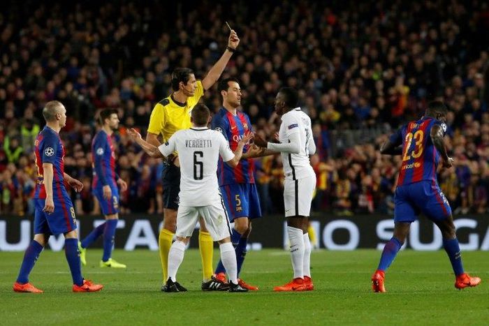 German referee Deniz Aytekin (C) shows a yellow card to Paris Saint-Germain's midfielder Blaise Matuidi (2ndR) during their UEFA Champions League round of 16 second leg football match at the Camp Nou stadium in Barcelona on March 8, 2017
