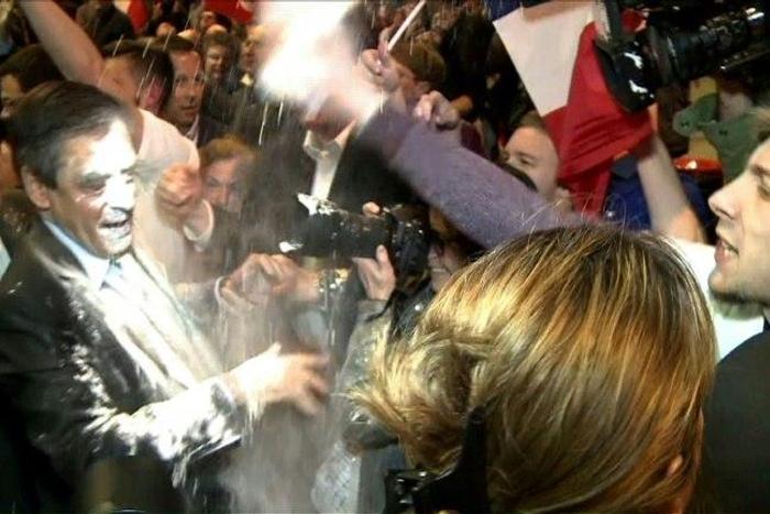 French presidential election candidate for the right-wing Les Republicains (LR) party Francois Fillon (C) reacting as a man throw flour at him on April 6, 2017 during a political rally in Strasbourg, northeastern France