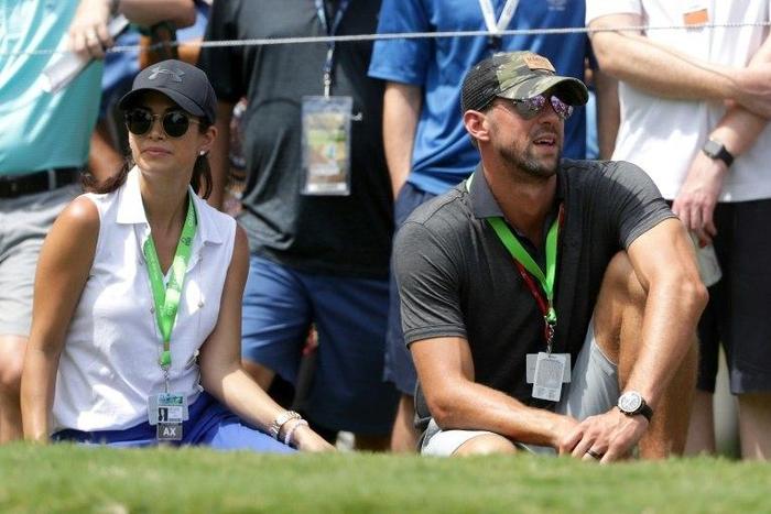 Swimmer Michael Phelps and his wife Nicole Johnson look on during the first round of the 2017 PGA Championship at Quail Hollow Club on August 10, 2017 in Charlotte, North Carolina