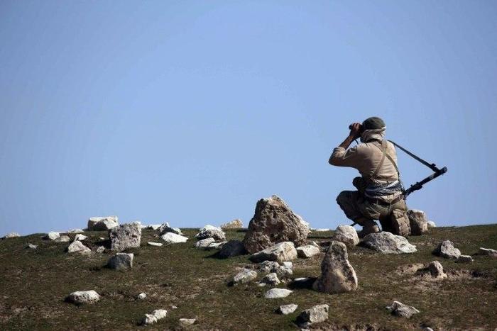 An Iraqi soldier watches enemy positions from Badush on March 9, 2017