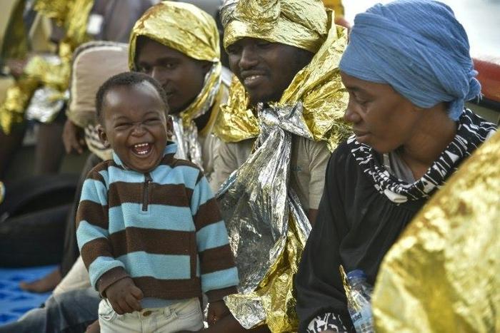 A baby laughs after being rescued at sea