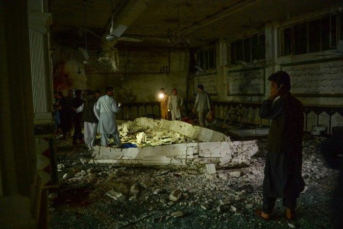 Afghan security personel inspect the site of a suicide bomb attack at a Shiite mosque in Herat on August 1, 2017