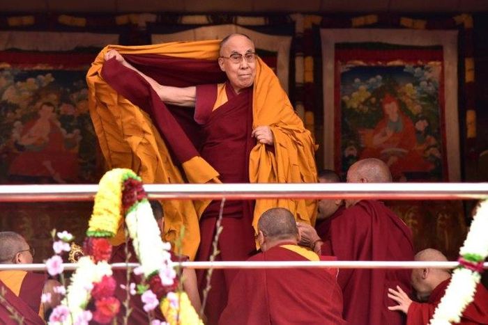 Exiled Tibetan spiritual leader the Dalai Lama adjusts his shawl as he arrives to deliver teachings to Buddhist followers at the Yiga Choezin ground in Tawang near the India-China border