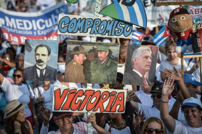 People display posters of (L to R) Cuban hero Jose Marti, Raul and Fidel Castro and current president Miguel Diaz-Canel during a May Day rally in 2018