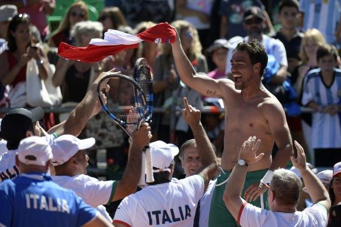 Italy's tennis player Fabio Fognini waves his jersey celebrating with teammates after defeating Argentina's Guido Pella on February 6, 2017