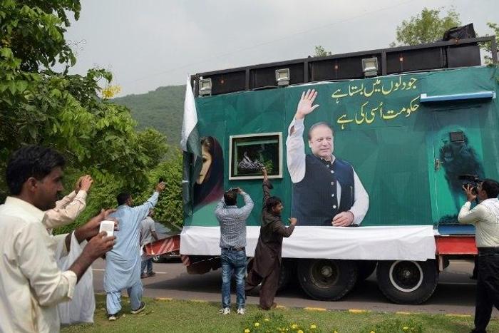 Pakistani supporters of deposed prime minister Nawaz Sharif gather around a container prepared for the rally led by Sharif in Islamabad